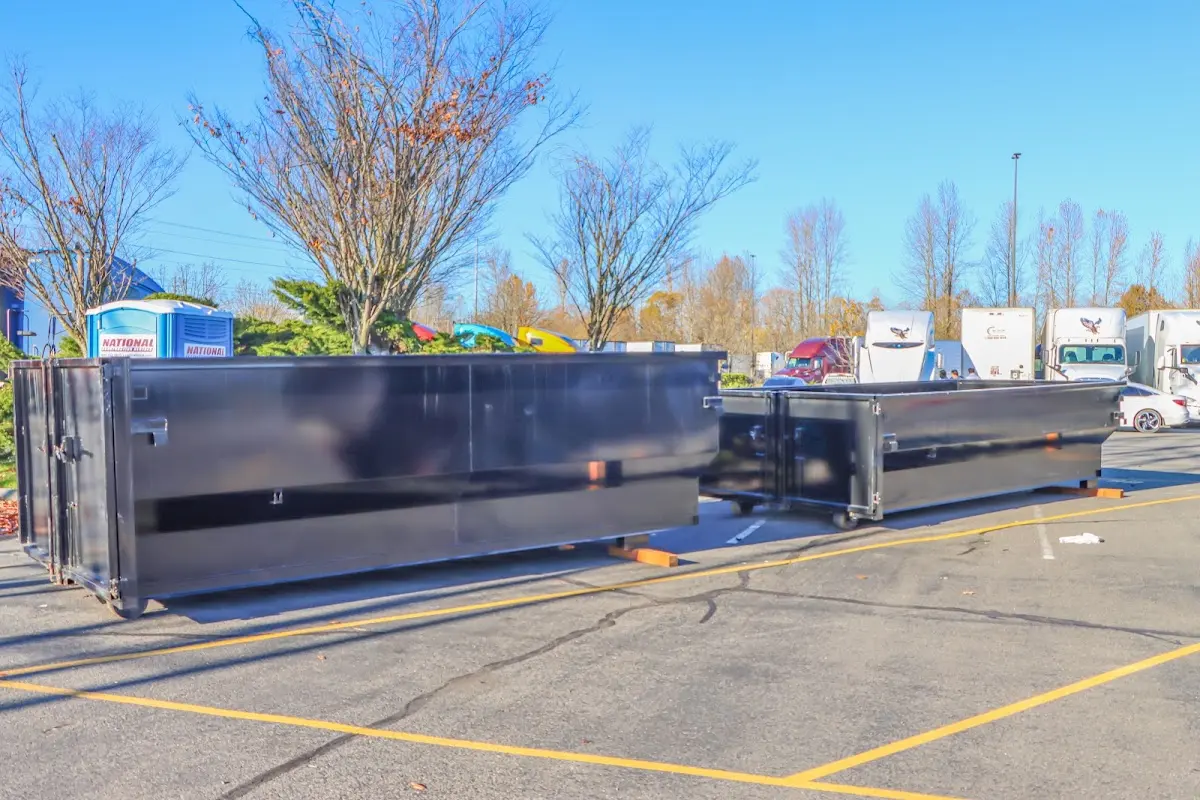 Professional dumpster rental service with roll-off container on residential driveway in Elba
